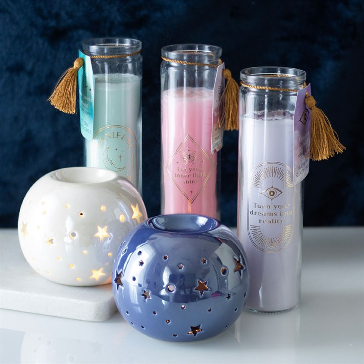 Set of candles and ceramic holders with star designs on a dark background