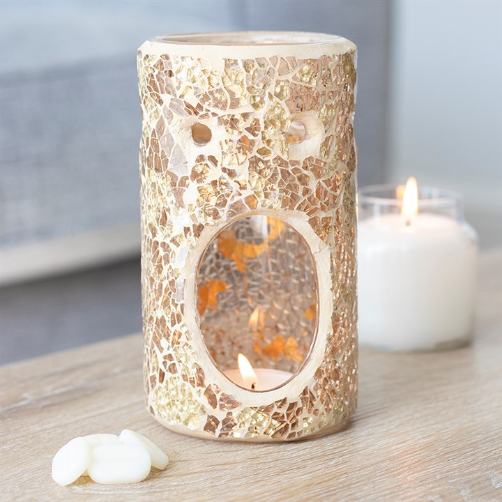 Mosaic-patterned candle holder with a lit candle on a wooden surface