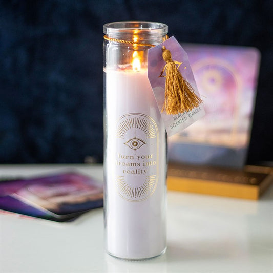 A white tube candle with blackberry fragrance, accentuated with gold text and amethyst crystal chips, displayed in a dimly lit environment.