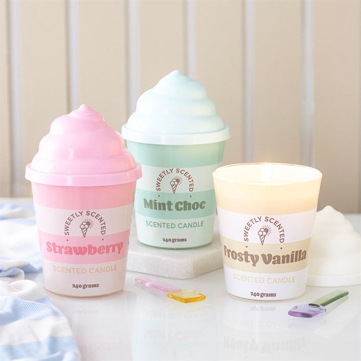 Three scented candles shaped like ice cream cones on a white surface with a light background.