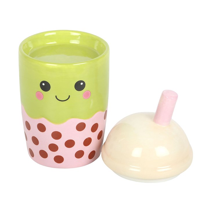 Green cup with a smiley face design, pink polka dot base, and beige lid on a white background