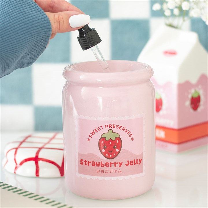 Pink strawberry jelly jar with a dropper being used, set against a blurred background.