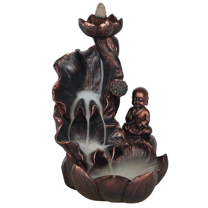 Decorative incense burner with a monk figure and lotus flower on a white background