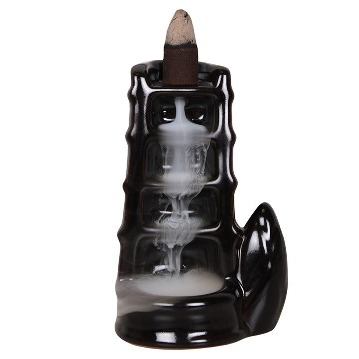 Black incense burner with smoke on a white background