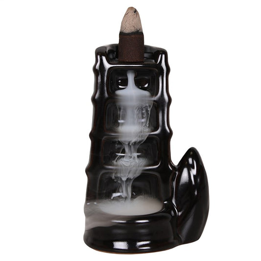 Black incense burner with smoke on a white background