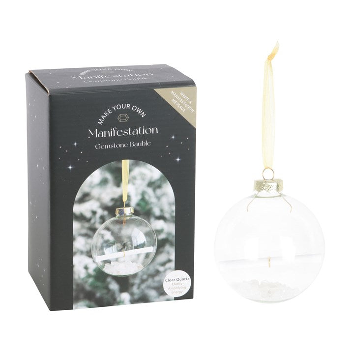 Clear glass ornament with gold accent in packaging labeled 'Make Your Own Manifestation Gemstone Bubble'.