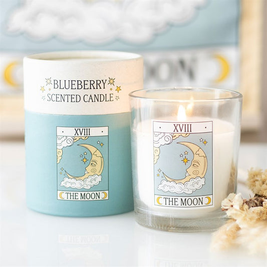 Blueberry scented candle labeled 'The Moon' with a blue candle holder on a light background.