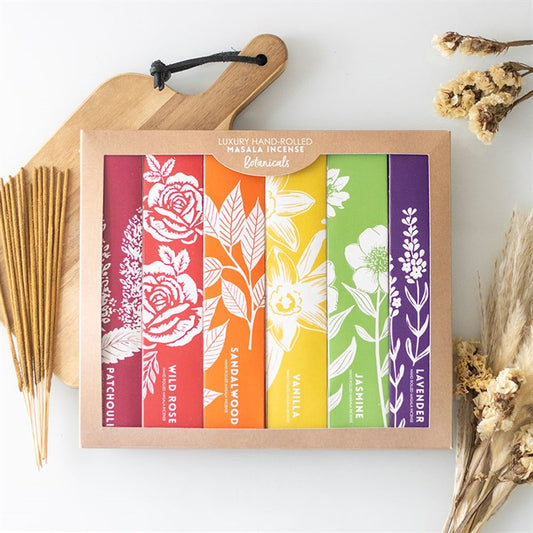 Box of hand-rolled masala incense sticks with colorful labels on a white background