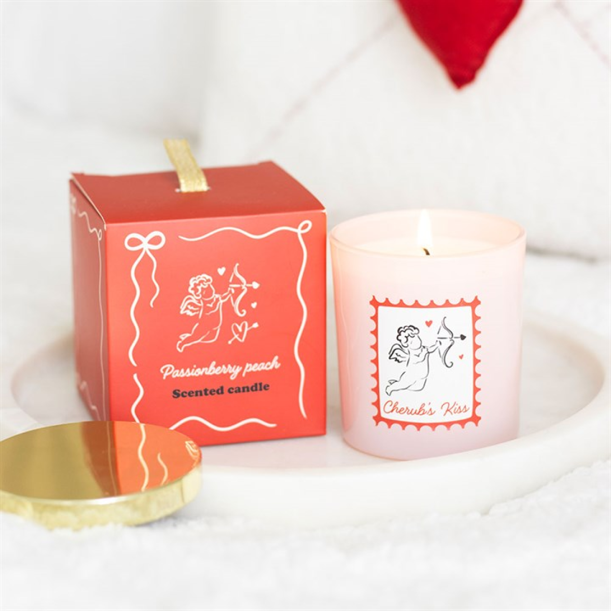Candle with packaging featuring cherub design and 'Cherub's Kiss' text on a white background.