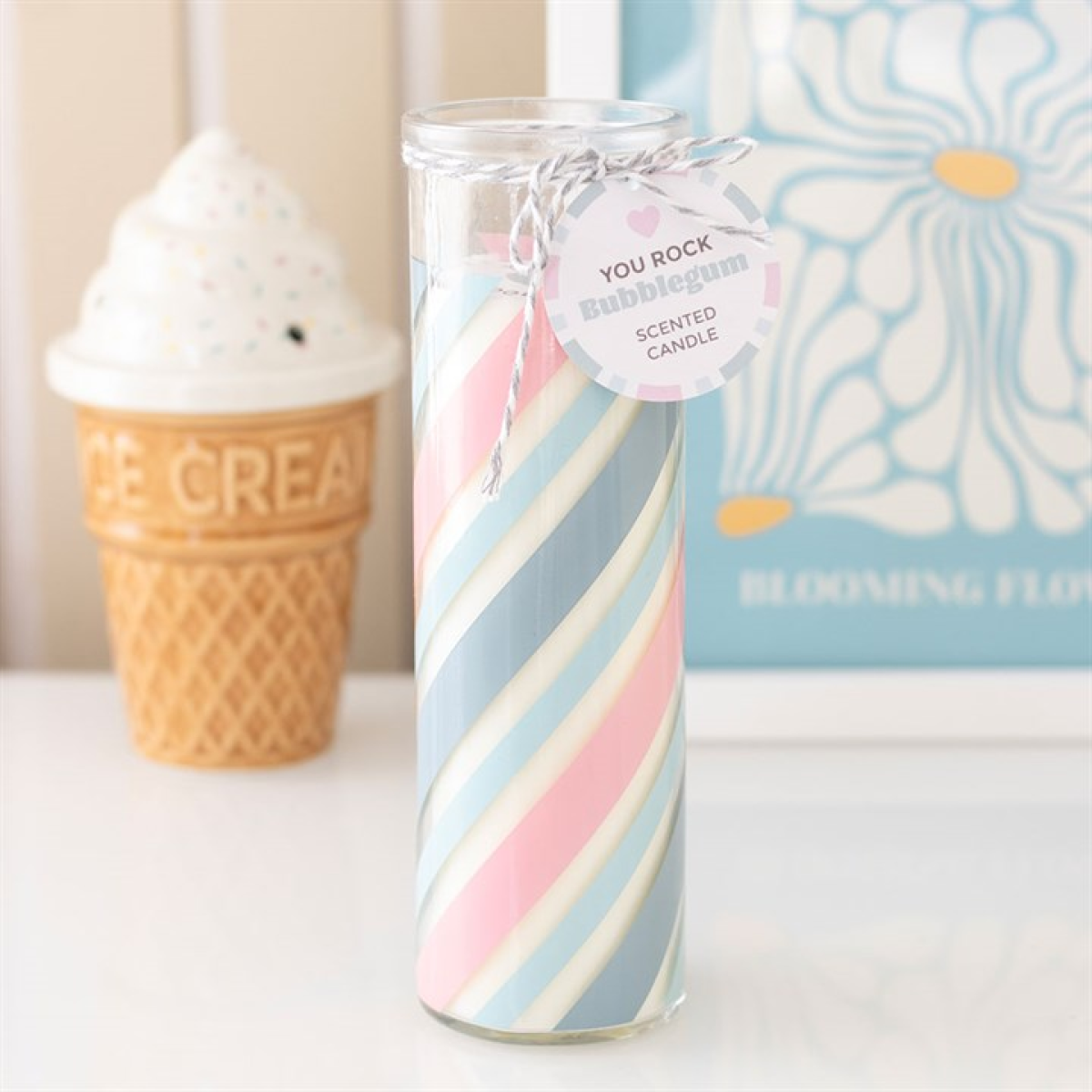 Striped candle with a 'You Rock' tag in front of an ice cream cone and floral book