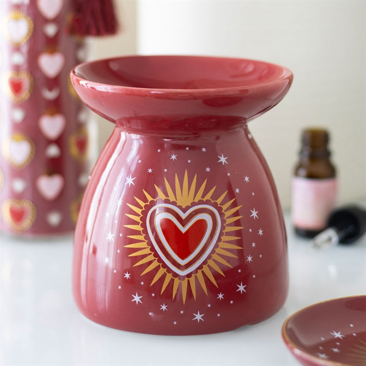 Red ceramic warmer with heart design on a white surface