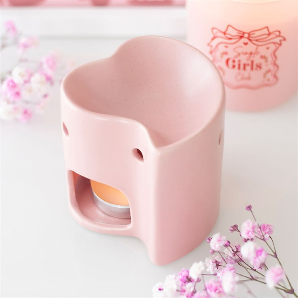 Heart-shaped pink product with floral decorations on a light background