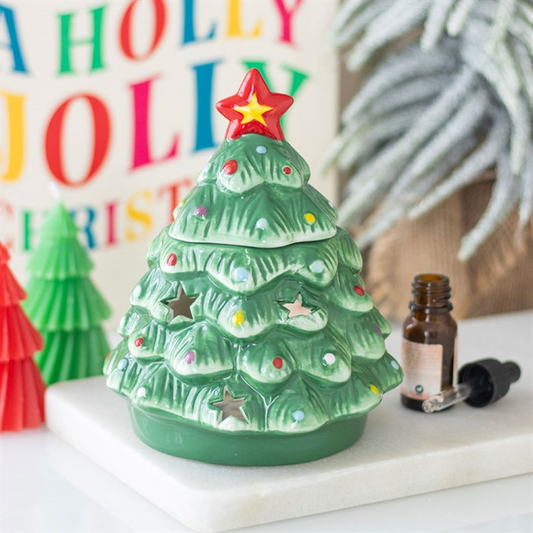 Green Christmas tree-shaped candle with a red star on top, surrounded by colorful letters and a bottle.