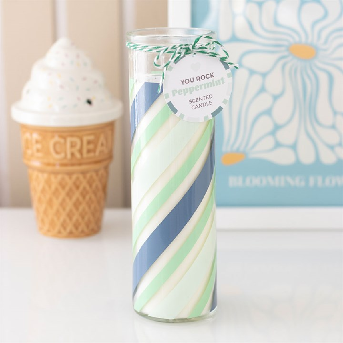 Scented candle with swirled design and decorative tag on a surface.