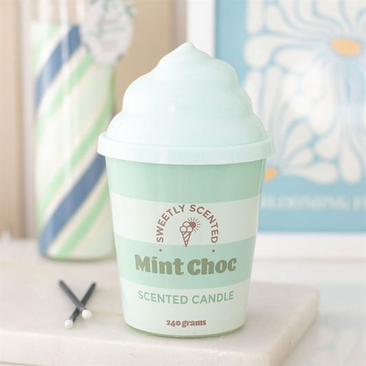 Mint green scented candle labeled 'Sweetly Scented Mint Choc' on a surface with a blurred background.